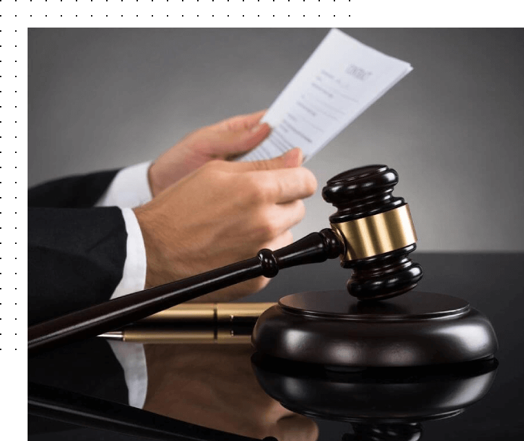 Gavel on table in front of judge holding papers