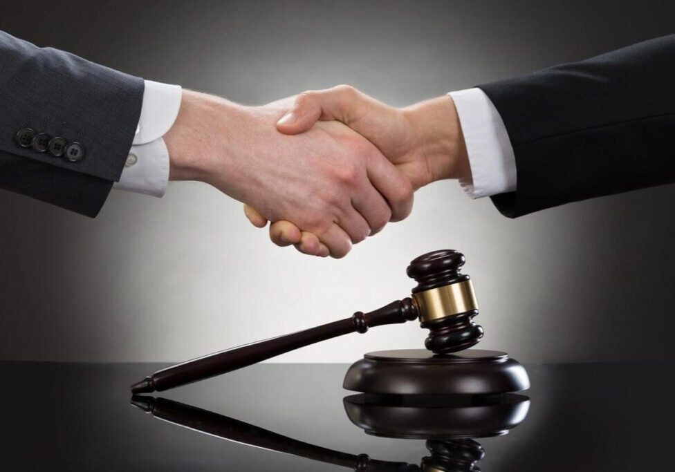 Hand shake and a gavel placed on table